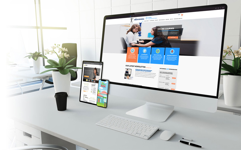 A website shown on a desktop monitor, tablet and smartphone on a white office desk